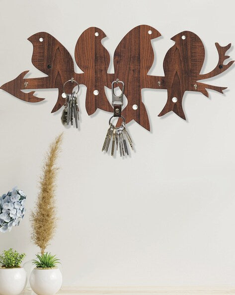 Wooden wall hook with bird designs holding keys against a light background