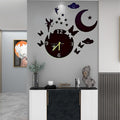 Decorative wall clock with butterfly and moon design on a gray wall.